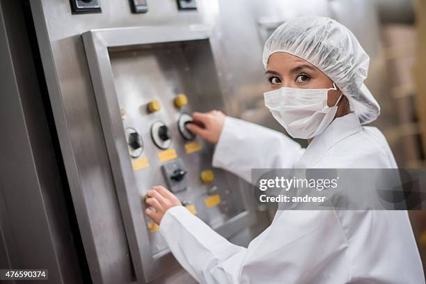 mulher de funcionamento de máquinas em uma fábrica de comida - fábrica de comida - fotografias e filmes do acervo