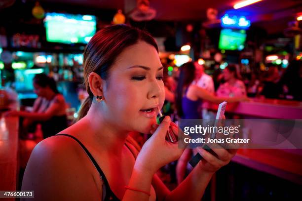 Lady-boy prostitute working for a brothel in Pattaya city puts on make up as she prepares for another night in the sex industry. With its reputation...