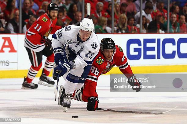 Ondrej Palat of the Tampa Bay Lightning and Teuvo Teravainen of the Chicago Blackhawks battle for the puck in the first period during Game Four of...