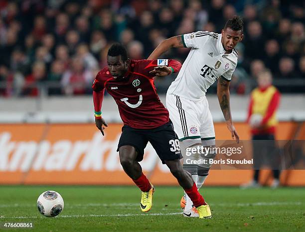 Mame Biram Diouf of Hannover 96 is challenged by Jerome Boateng of FC Bayern Muenchen during the Bundesliga match between Hannover 96 and FC Bayern...