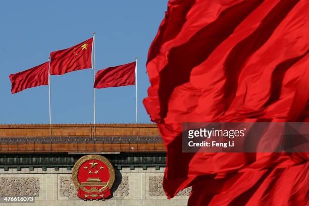 Red flags flutter in the wind near the Chinese national emblem outside the Great Hall of the People where sessions of the Chinese People's Political...