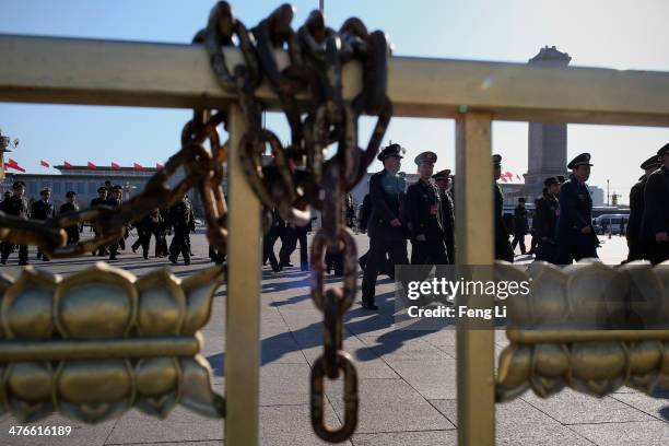 Military delegates from the Chinese People's Liberation Army walk towards the Great Hall of the People for a plenary meeting of the National People's...