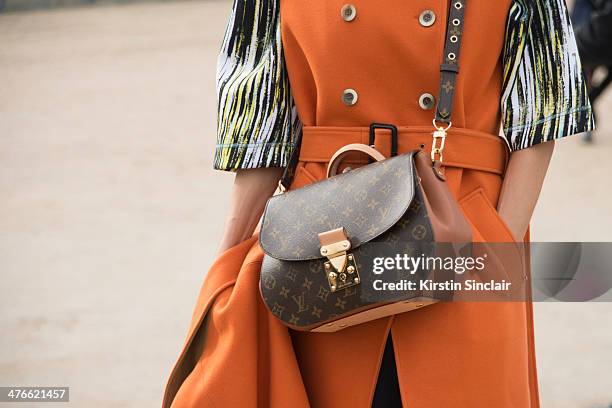 Guest wears a Louis Vuitton bag, Ana Locking coat and Kenzo shirt on day 4 of Paris Collections: Women on February 28, 2014 in Paris, France.