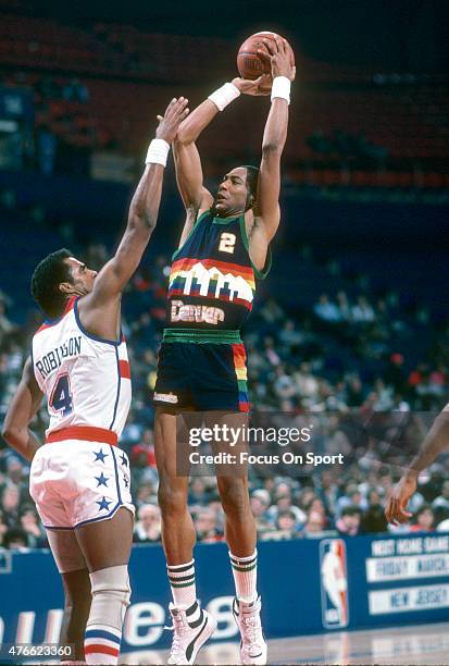 Alex English of the Denver Nuggets shoots over Cliff Robinson of the Washington Bullets during an NBA basketball game circa 1985 at the Capital...