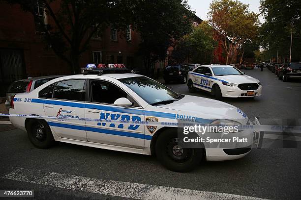 Police car is parked at a crime scene where three people were shot on June 10, 2015 in the Gowanus area of the Brooklyn Borough of New York City. In...