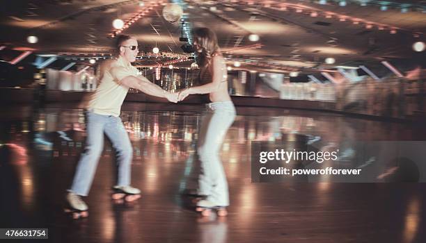 retro 70's roller disco couple in blurred motion - roller rink stock pictures, royalty-free photos & images