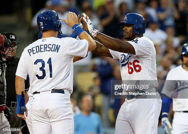 Yasiel Puig of the Los Angeles Dodgers celebrates with Joc Pederson and Alberto Callaspo after all three score on Puig's three run home run in the...