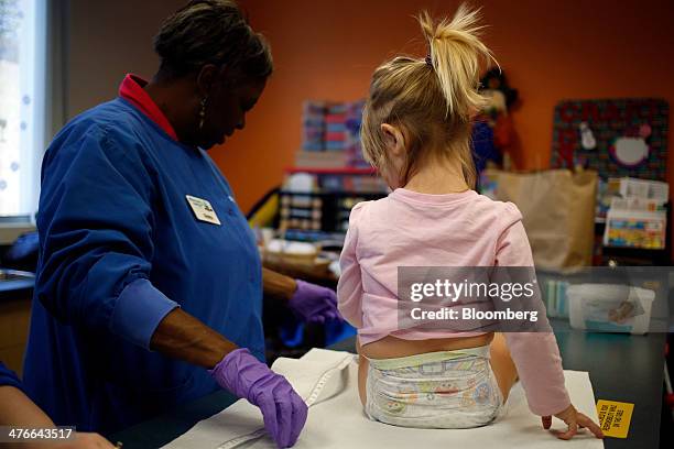 Toddler participating in a consumer diaper study has the fit of her diaper measured at Procter & Gamble & Co.'s baby care laboratory in Cincinnati,...