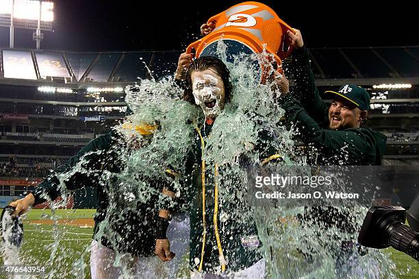 Josh Reddick of the Oakland Athletics has Gatorade poured on him by Billy Butler and Stephen Vogt after hitting a walk off RBI against the Texas...