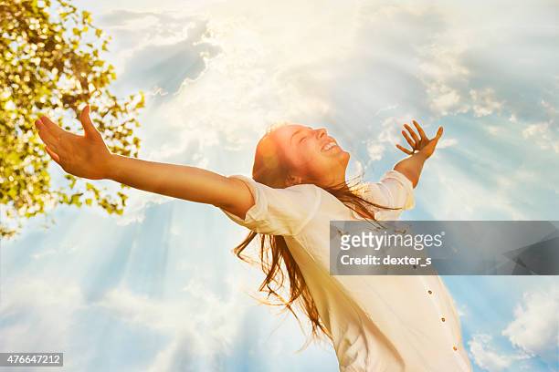 giovane donna alzando le braccia e godersi una giornata di sole - arms outstretched foto e immagini stock