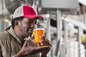 Black man working in a small brewery tasting beer