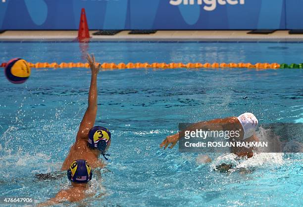 Singapore's Sean Ang Wei Ming throws the ball past Malaysia's Chiew Chern Kwang during their water polo men's round robin match at the 28th Southeast...