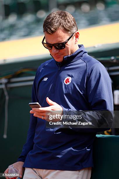 General Manager Ben Cherington of the Boston Red Sox checks messages on his phone prior to the game against the Oakland Athletics at O.co Coliseum on...