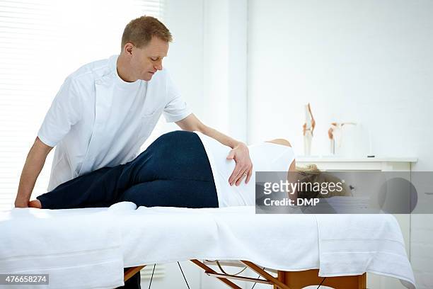 woman receiving osteopathic therapy - male crotch stock pictures, royalty-free photos & images