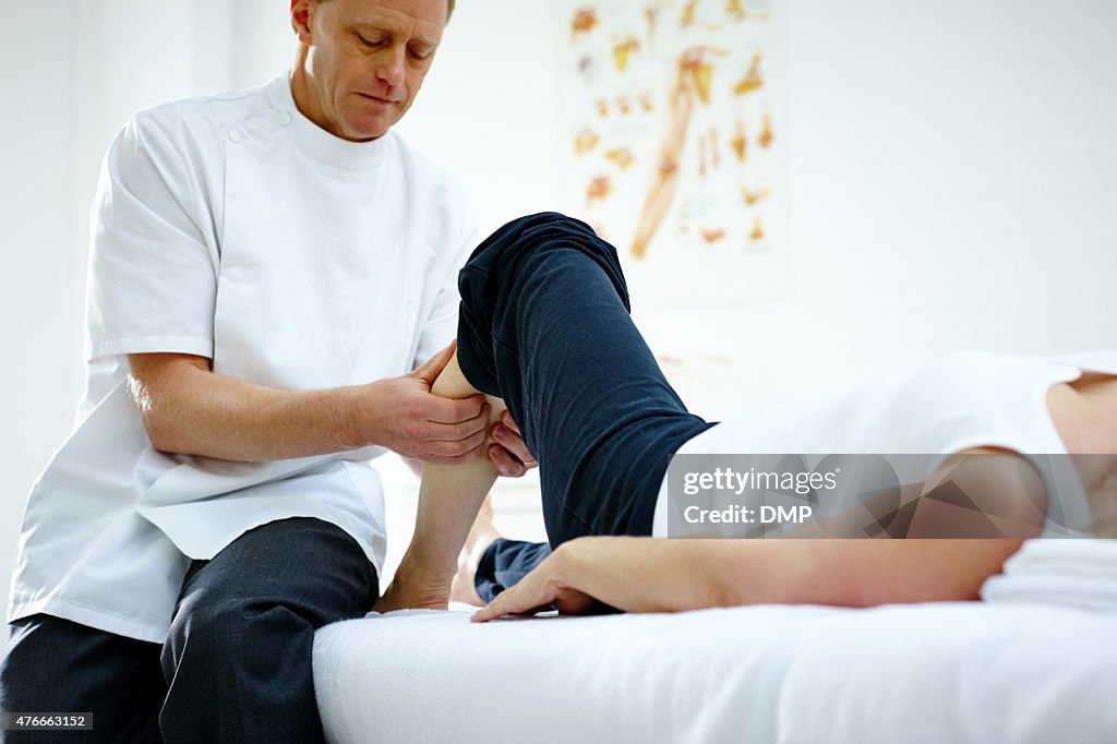 Physiotherapist working on woman's lower leg