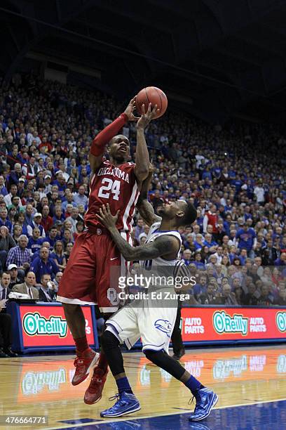 Buddy Hield of the Oklahoma Sooners shoots over Naadir Tharpe of the Kansas Jayhawks in the second half at Allen Fieldhouse on February 24, 2014 in...