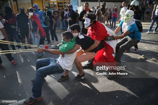 Protesters sling stones at Venezuelan national guard troops during an anti-government demonstration on March 4, 2014 in Caracas, Venezuela. Wednesday...
