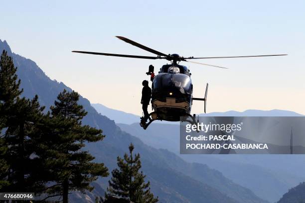Gendarmerie helicopter flies as it transports rescue firemen and Gendarmes to the GR 20 trail for the research of missing people on June 11 near Asco...