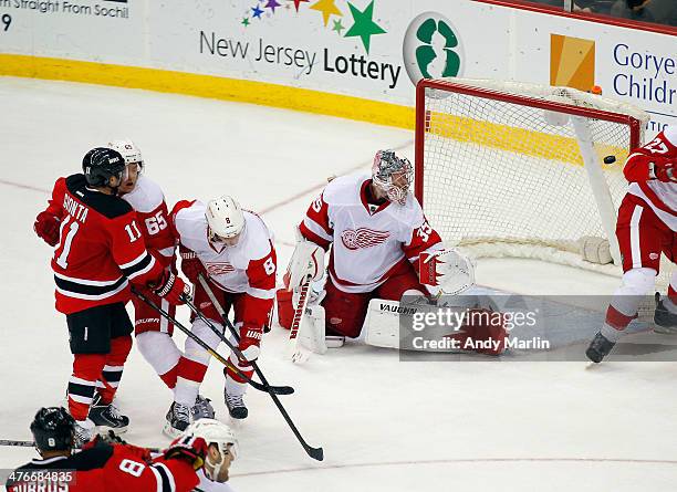 Goaltender Jimmy Howard of the Detroit Red Wings looks behind him at the puck in the net on the game-winning goal by Stephen Gionta of the New Jersey...