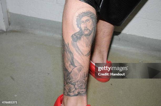 In this handout photo provided by the Miami Beach Police Department and released on March 4 singer Justin Bieber displays his tattoos for police...