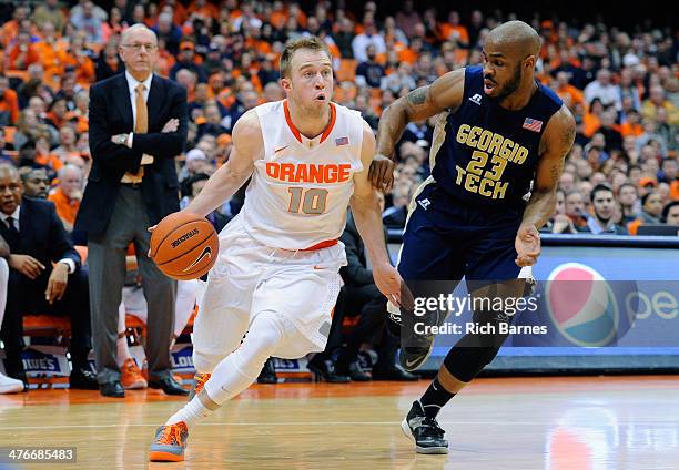 Trevor Cooney of the Syracuse Orange drives to the basket against the defense of Trae Golden of the Georgia Tech Yellow Jackets during the second...