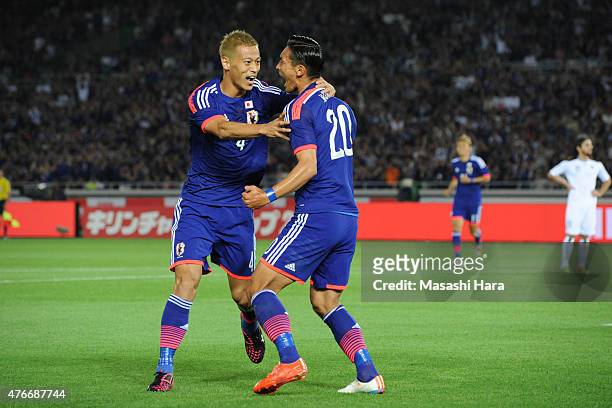Keisuke Honda and Tomoaki Makino of Japan celebrate the second goal during the international friendly match between Japan and Iraq at Nissan Stadium...