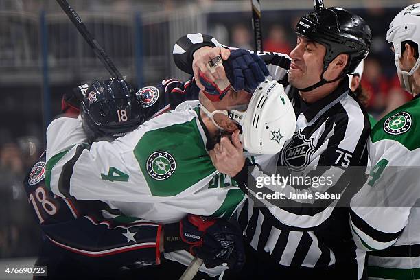 Linesmen Derek Amell tries to break up a scrum between R.J. Umberger of the Columbus Blue Jackets and Brenden Dillon of the Dallas Stars during the...