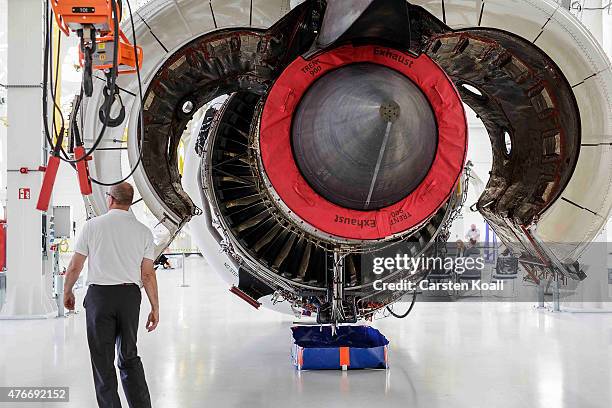 An employee explains a jet engine after German President Joachim Gauck visits the Rolls-Royce Mechanical Testing Operations Center on June 11, 2015...