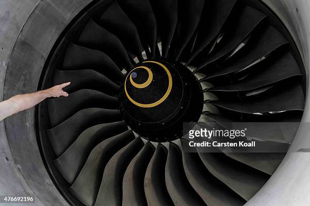 An employee explains a jet engine after German President Joachim Gauck visits the Rolls-Royce Mechanical Testing Operations Center on June 11, 2015...