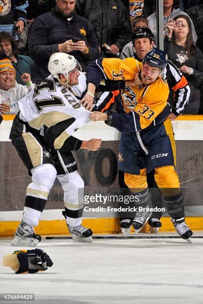 Robert Bortuzzo of the Pittsburgh Penguins fights Colin Wilson of the Nashville Predators at Bridgestone Arena on March 4, 2014 in Nashville,...