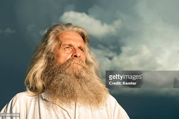 long-haired prophet standing in front of dramatic sky - senior man grey long hair stock pictures, royalty-free photos & images