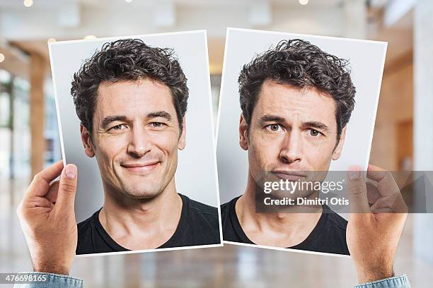 hands holding portrait of man being happy and sad - bipolar stock-fotos und bilder