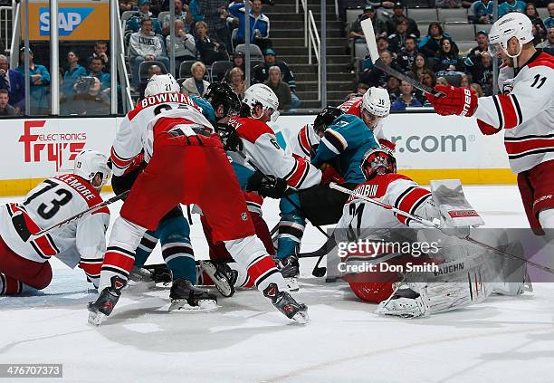Members of the San Jose Sharks look for a rebound against Anton Khudobin and Drayson Bowman of the Carolina Hurricanes during an NHL game on March 4,...