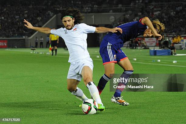 Humam Tareq Faraj of Iraq and Takashi Usami of Japan compete for the ball during the international friendly match between Japan and Iraq at Nissan...