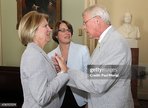 Senators Shelley Capito , Amy Klobuchar and Roger Wicker gather before a group photo to celebrate National Seersucker Day at the U.S. Capitol...