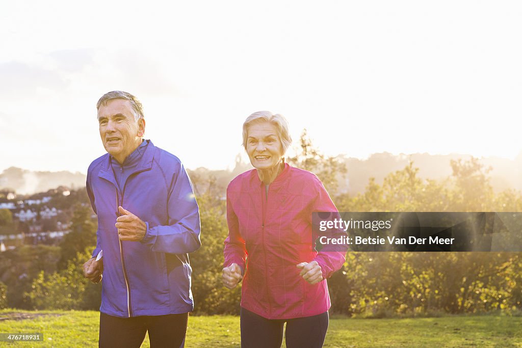 Senior couple jogging outdoors.