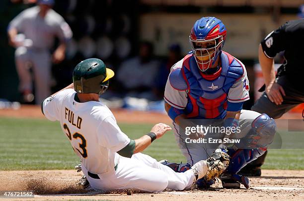 Carlos Corporan of the Texas Rangers tags out Sam Fuld of the Oakland Athletics as he tries to score from third base on a fly-out hit by Josh Reddick...
