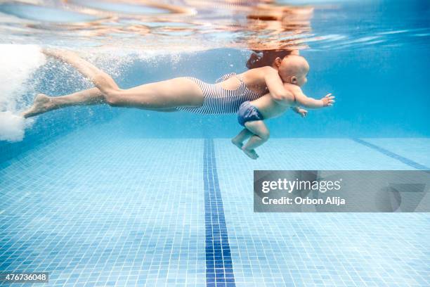 mother swimming with baby boy - swim lessons pool stock pictures, royalty-free photos & images