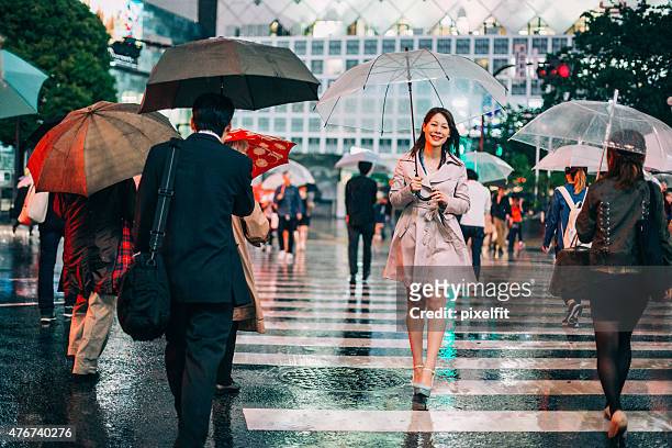 portrait of smiling japanese woman walking in the rain - asia rain stock pictures, royalty-free photos & images