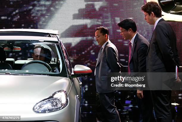 Visitors look at a Opel Adam automobile, produced by General Motors Co. , as it stands on display at the company's stand on day two of the 84th...