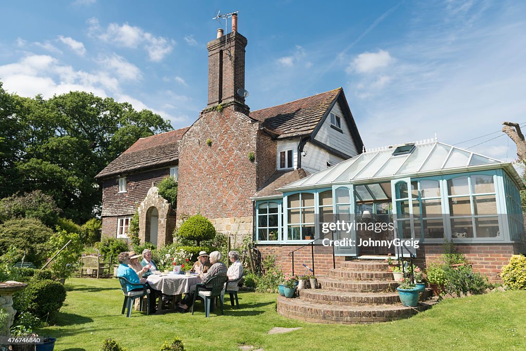 Group of senior women friends having afternoon tea alfresco