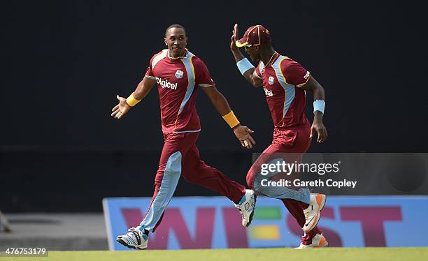 Dwayne Bravo of the West Indies celebrates with Darren Sammy after dismissing Ben Stokes of England during the 3rd One Day International between the...