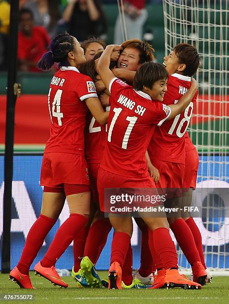 Teammates swarm Wang Lisi of China PR after she scored the game winning goal against the Netherlands during the FIFA Women's World Cup Canada 2015...