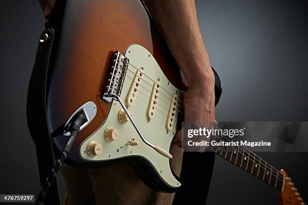 Detail of a guitarist holding a Fender Classic Series Stratocaster Lacquer electric guitar, taken on May 21, 2013.