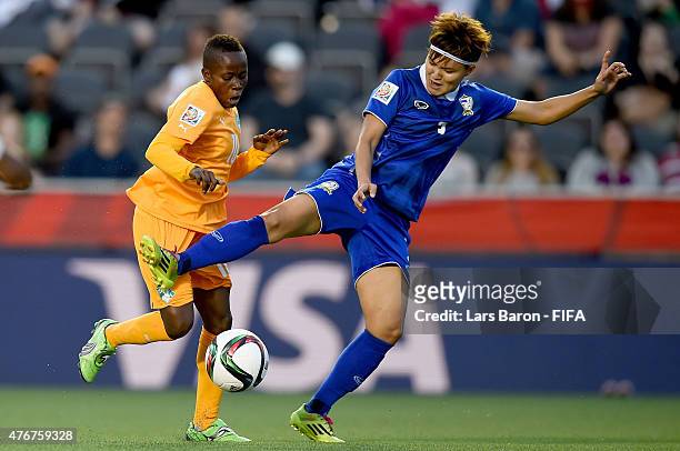 Ange Nguessan of Cote D'Ivoire is challenged by Natthakarn Chinwong of Thailand during the FIFA Women's World Cup 2015 Group B match between Cote...