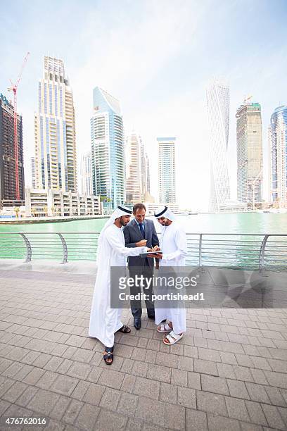 businessmen standing in front of city skyline - persian gulf stock pictures, royalty-free photos & images