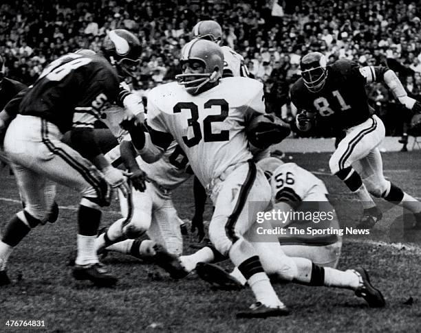 Running Back Jim Brown of the Cleveland Browns against Carl Eller and Rip Hawkins of the Minnesota Vikings circa 1964 at Cleveland Municipal Stadium...