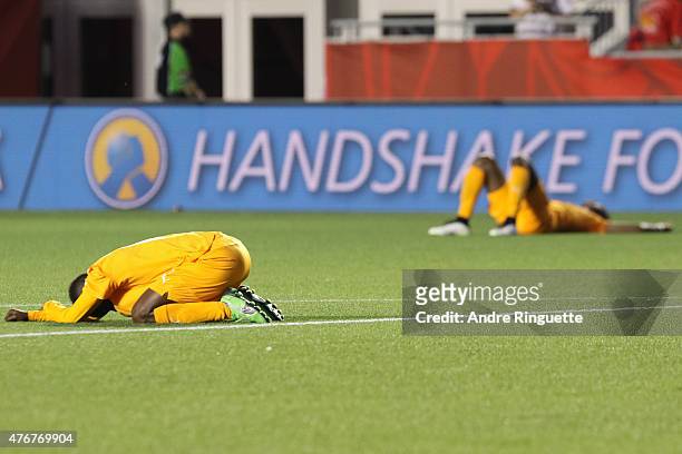 Ange N'Guessan of Cote d'Ivoire falls the the ground dejected along with a teammate in the background after their loss against Thailand in the FIFA...