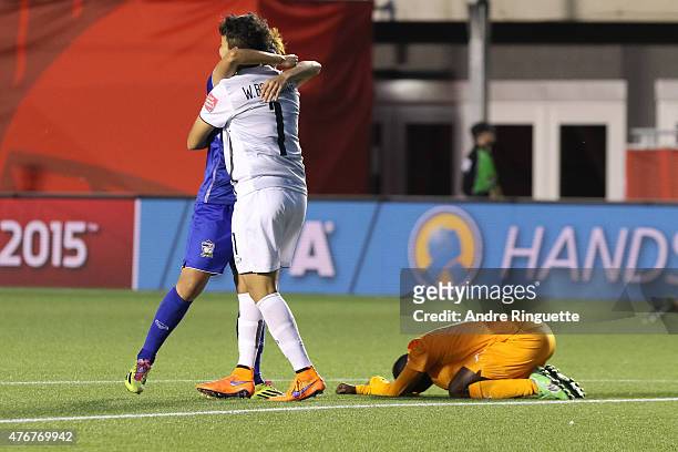 Waraporn Boonsing of Thailand celebrates her team's win with a team mate as Ange N'Guessan of Cote d'Ivoire is dejected during the FIFA Women's World...