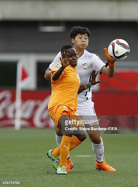 Waraporn Boonsing of Thailand challenges for the ball with Ange Nguessan of Cote d'Ivore during the FIFA Women's World Cup 2015 group B match between...